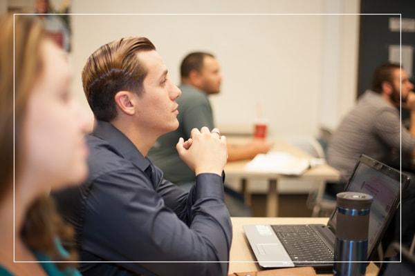 Student sitting at a classroom desk with laptop